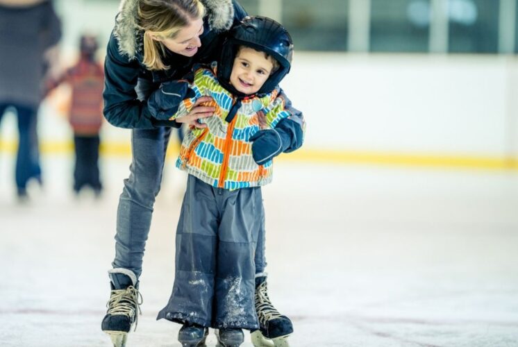 Family skating at Skate for a Cause Southfield Sports Arena as a child learns to skate with support during the community event
