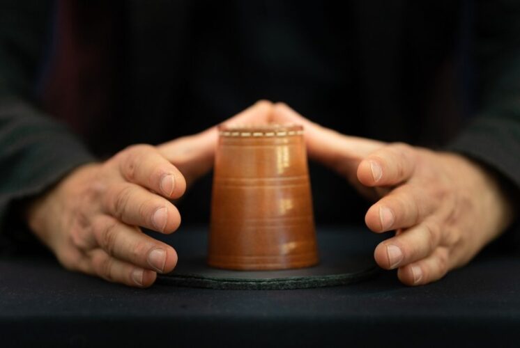 Magician performs a classic cup trick during the A2 magic show at Ann Arbor Hands On Museum as part of a fun family performance
