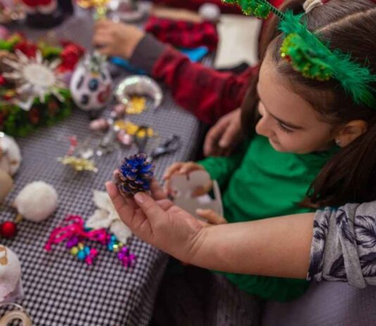 Craft with a Cop at The Hawk Child creating a holiday craft at Craft with a Cop Farmington Hills with colorful supplies and hands on guidance from an adult