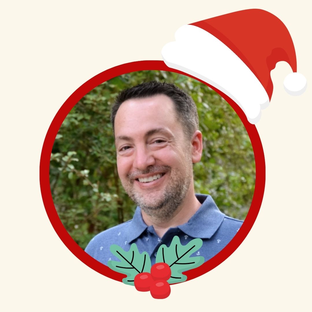 David Arkin, Editor-in-Chief at Metro Parent, smiling in a holiday-themed portrait with a Santa hat graphic.