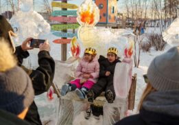 Kids pose on an ice throne at the Fire and Ice Festival at Robert C. Valade Park during family friendly winter fun along the riverfront