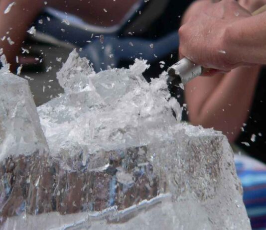 Frozen Night at Greenmead Historical Village Close up of ice sculpting in progress during Frozen Night at Greenmead Historical Village showing ice chips flying as a block is carved