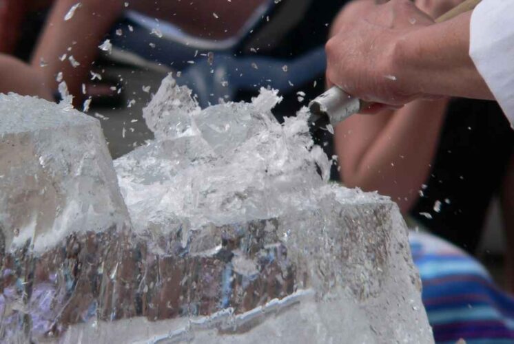 Close up of ice sculpting in progress during Frozen Night at Greenmead Historical Village showing ice chips flying as a block is carved