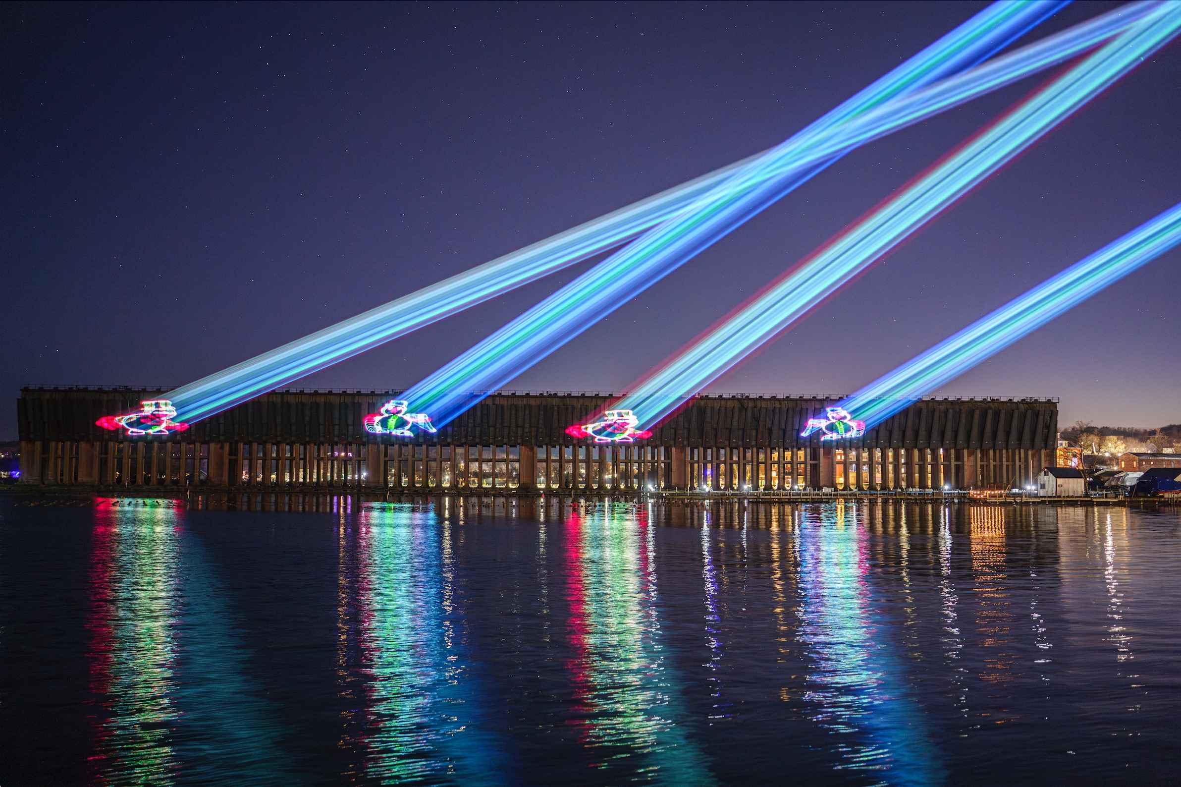 Holiday laser lights shine across the Lower Harbor Ore Dock in Marquette, a Michigan drive-through Christmas lights display beyond metro Detroit.