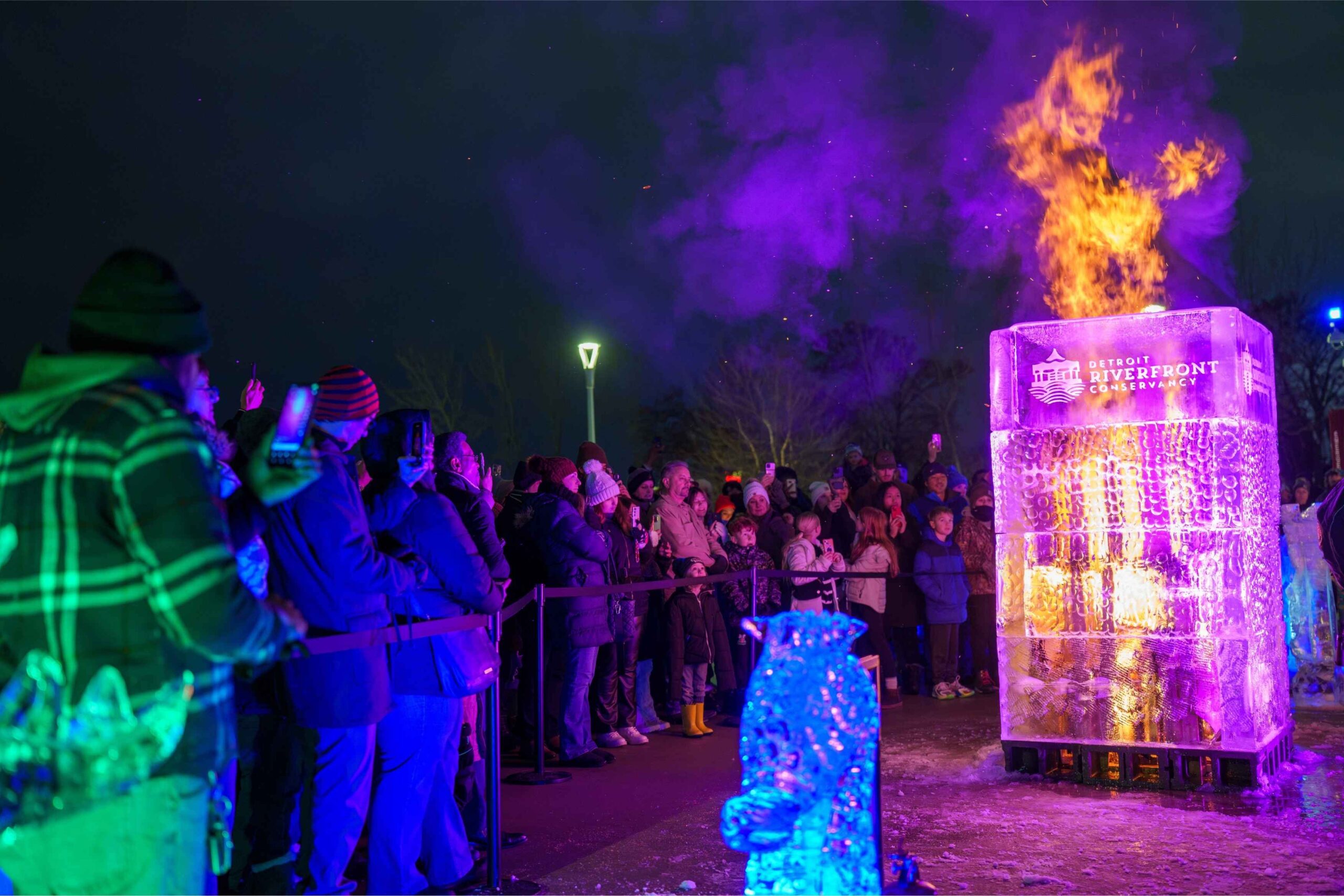 Crowds watch a glowing ice sculpture fire display during the Hyde Park Art Center MLK Day celebration with free family programming