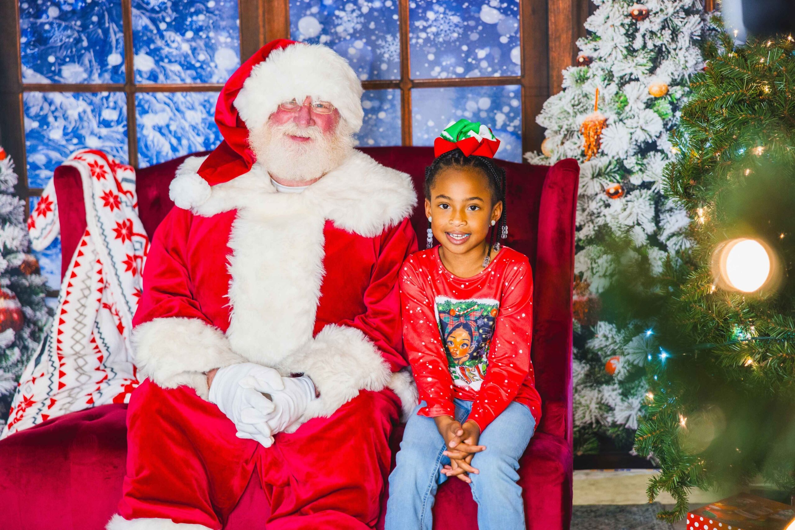 A child sits with Santa during a holiday photo at Magic of Lights in Detroit showing a festive scene that reflects the event’s family appeal.