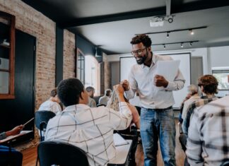 Professor engaging with students in a small college classroom in southeast Michigan.