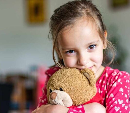 Child hugging a stuffed animal during the Stuff A Pet event where kids adopt and take home a plush toy at a family activity