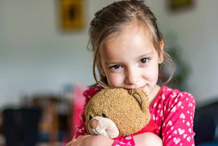 Child hugging a stuffed animal during the Stuff A Pet event where kids adopt and take home a plush toy at a family activity