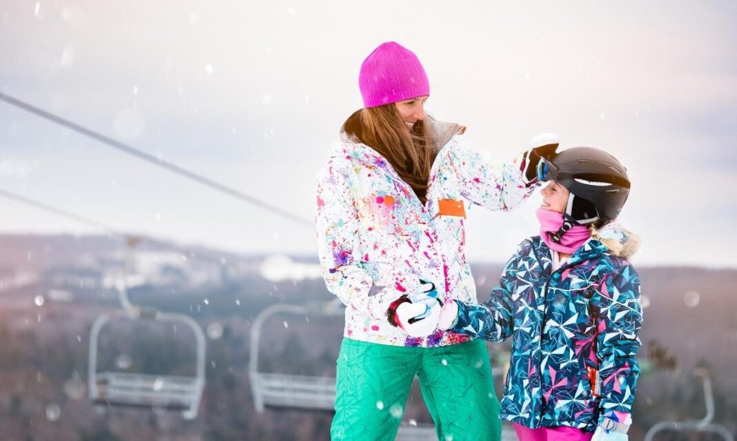A mom and child share a moment by the ski lift at Treetops Resort during a winter family getaway with skiing and snowy outdoor fun.