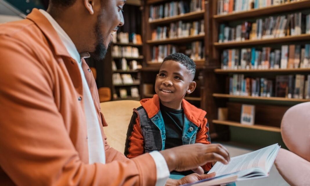 African American family book expo moment showing a parent reading with a child during a family literacy and storytelling experience
