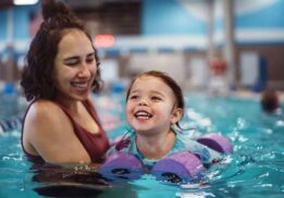 Family enjoying Ann Arbor Open Swim at Goldfish Swim School during a warm indoor family swim time for kids and parents.
