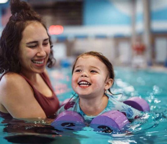 Family enjoying Ann Arbor Open Swim at Goldfish Swim School during a warm indoor family swim time for kids and parents.
