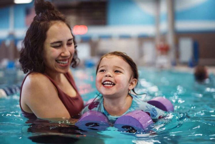Family enjoying Ann Arbor Open Swim at Goldfish Swim School during a warm indoor family swim time for kids and parents.