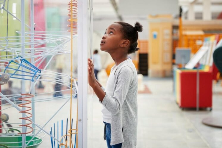 Girl exploring hands-on science exhibits during Discovery Days Women and Girls in Science at Cranbrook Institute of Science