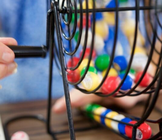 Close up of a bingo cage during Family Bingo Bash, showing colorful bingo balls being drawn for a family game night event