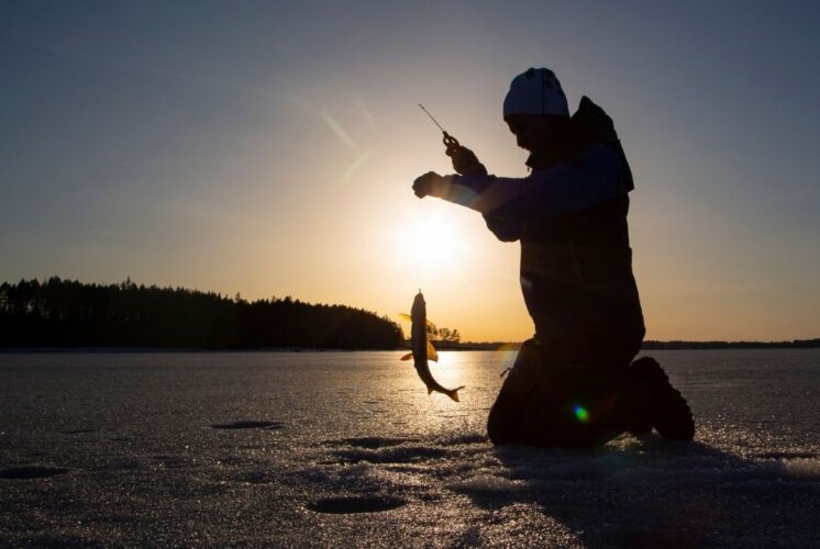 Child ice fishing at Ice Fishing Derby Independence Lake during a winter family event with kid and adult fishing divisions