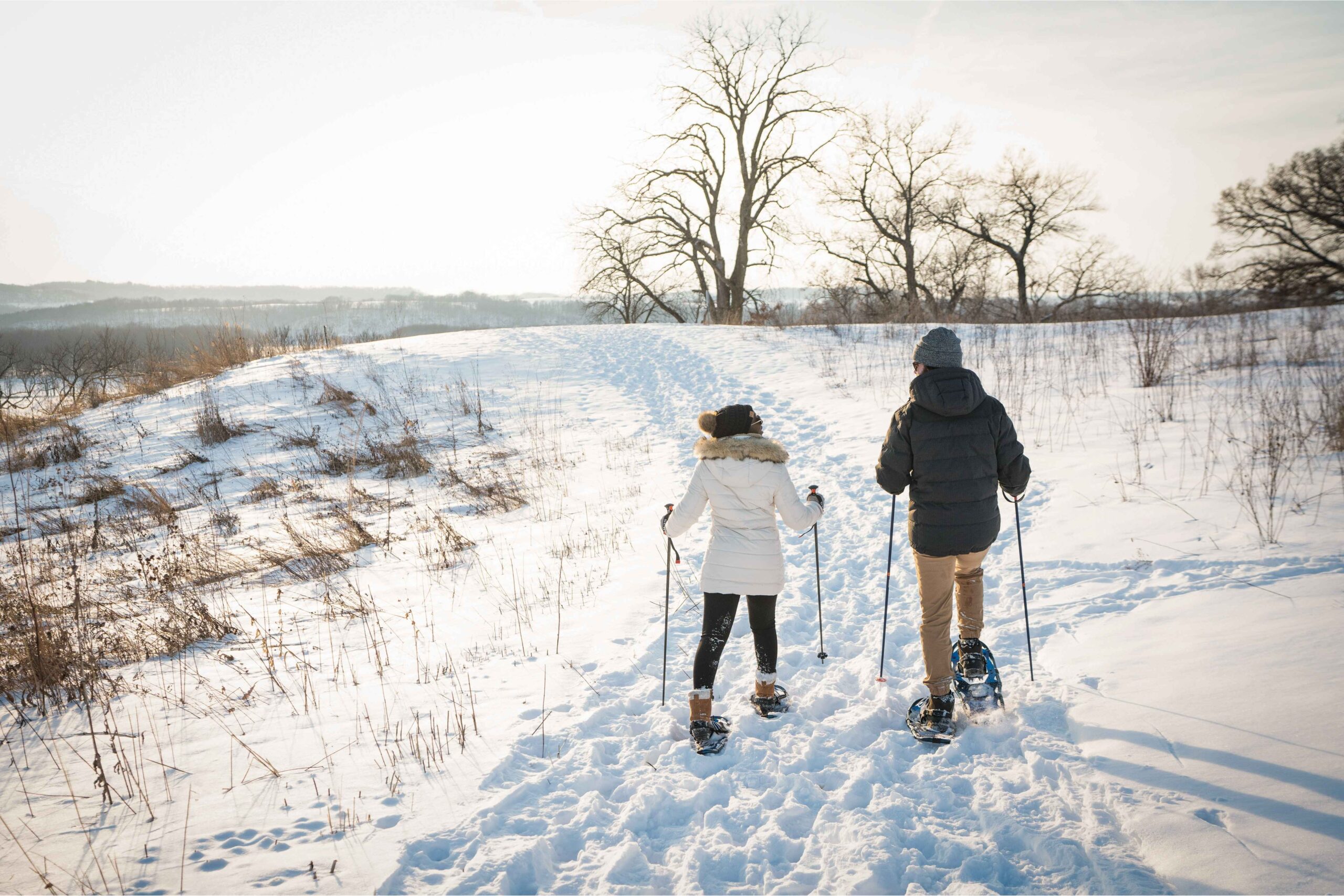 Family snowshoeing along a snowy trail during a Midwest winter escape near Metro Detroit, enjoying outdoor winter activities together