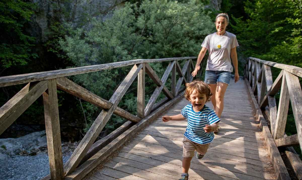 Young child exploring nature with a caregiver during the Morning Munchkins nature program at Red Oaks Nature Center for preschool kids.