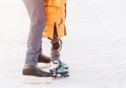 Adult and child enjoy open ice skating at Stine Community Park during a family friendly outdoor skating session in winter