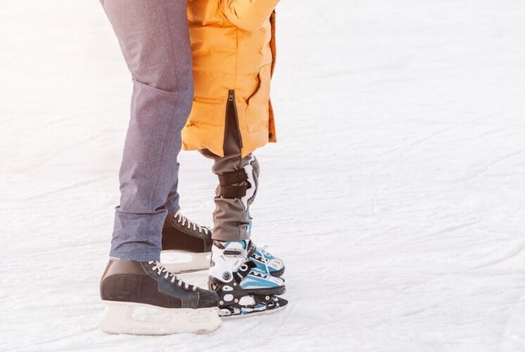 Adult and child enjoy open ice skating at Stine Community Park during a family friendly outdoor skating session in winter