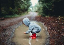 Child exploring puddles during the Puddle Jumpers nature program, a hands on outdoor activity for preschool kids at Wint Nature Center.