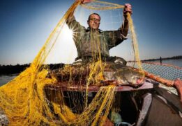 Angler demonstrating fishing nets at the Ultimate Fishing Show Detroit, showcasing commercial fishing techniques and gear at the show.