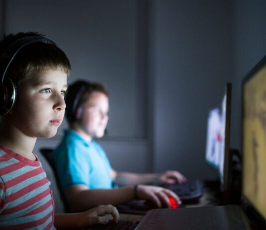 Kids play video games during Video Game Night at The Robot Garage, a supervised evening with kid friendly games and pizza included