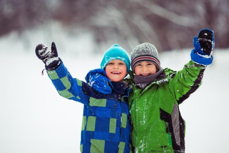 Children enjoy winter orienteering during a family outdoor program, exploring snowy trails and learning navigation skills together