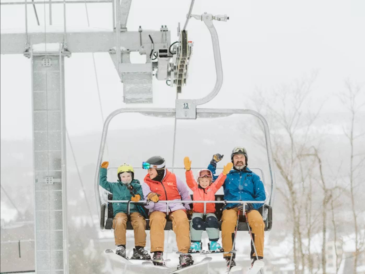 Family rides a chairlift at Boyne Mountain in Boyne Falls, Michigan during a winter ski getaway.