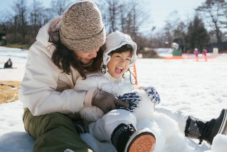 Family enjoying snow play during Cold Rush at Warren City Square, a free winter festival with outdoor activities, bonfires and fun for kids and parents.