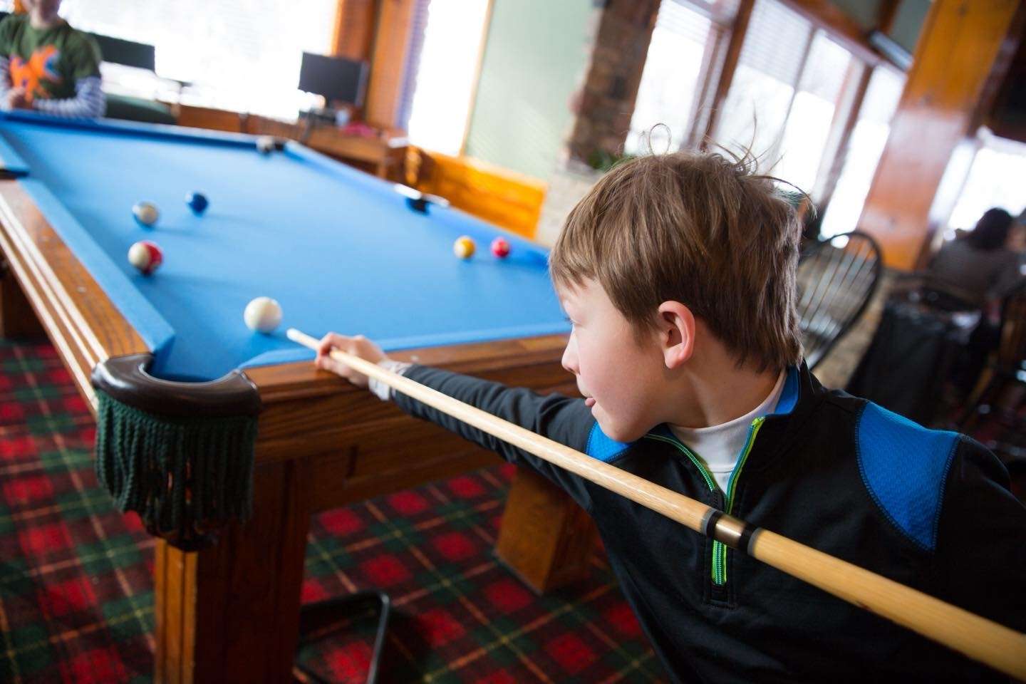 Child playing pool at a family friendly resort in Gaylord, Michigan during a winter getaway in northern Michigan.