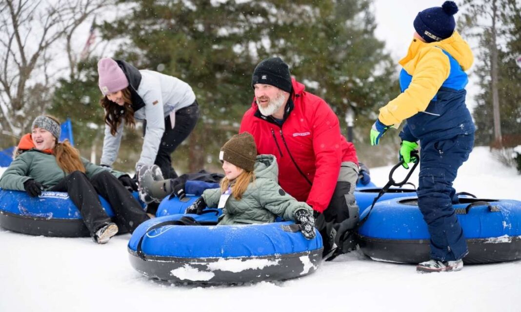 Family snow tubing in Gaylord, Michigan during a winter getaway with kids enjoying outdoor snow activities.