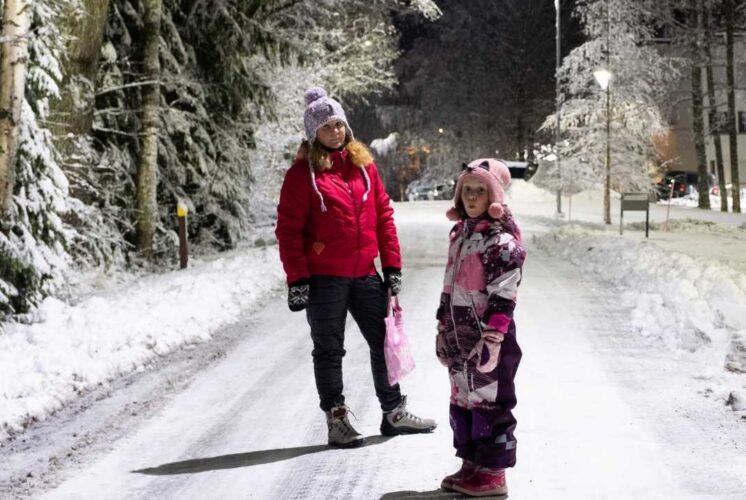 Family bundled up for Light the Night Flannel 5K walking a snowy trail at Waterford Oaks during the winter evening race