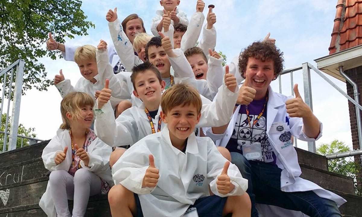 Kids in lab coats give thumbs up during hands on science activities at Mad Science summer camp in metro Detroit