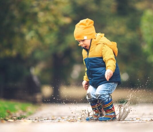 Nature Play for Pre K at DNR Outdoor Adventure Center Preschool child splashing in a puddle during Puddle jumpers at Wint Nature Center, a hands on nature program with stories and crafts for young kids.