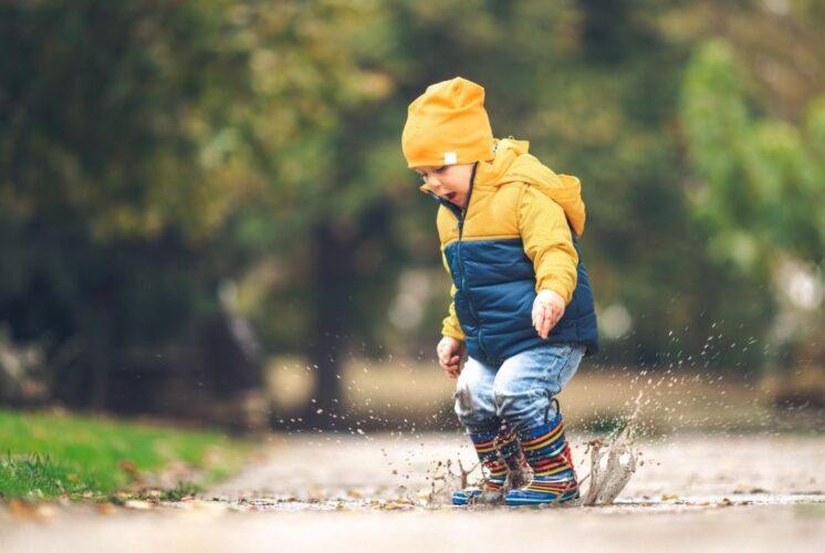 Preschool child splashing in a puddle during Puddle jumpers at Wint Nature Center, a hands on nature program with stories and crafts for young kids.