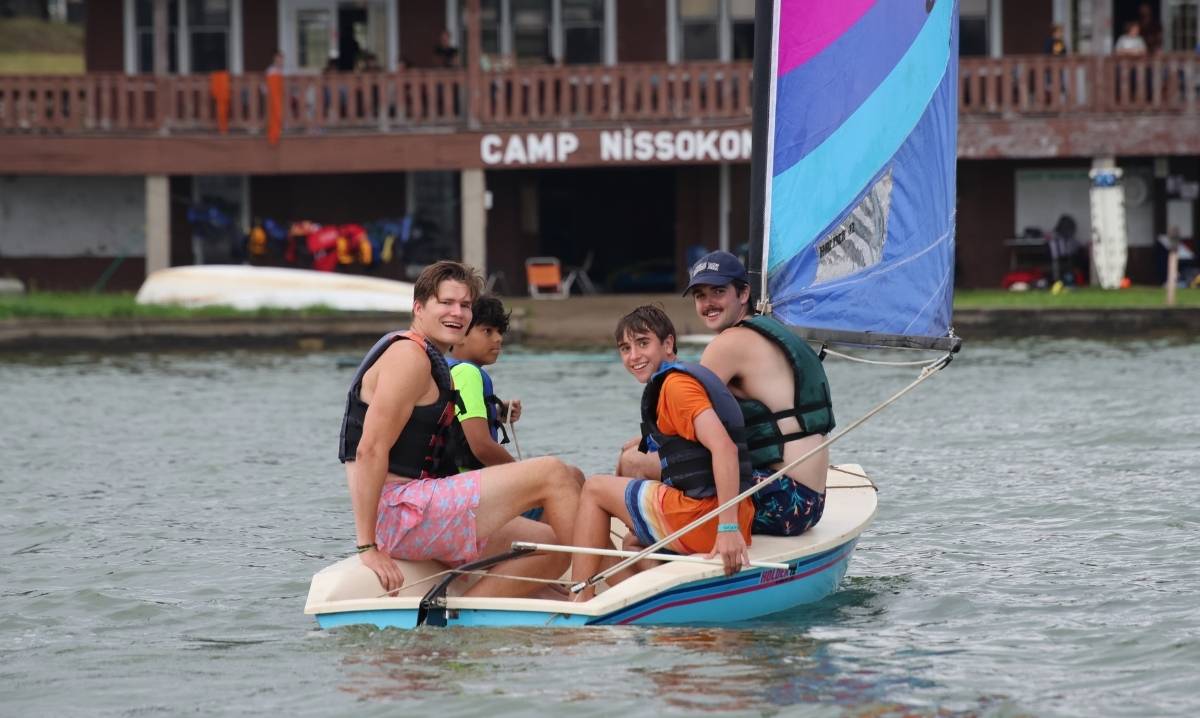 Campers sail together on Lake Huron at YMCA Camp Nissokone, enjoying a summer camp experience focused on outdoor adventure and teamwork.