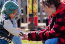 Parent and child collecting eggs at the Blake’s Orchard and Cider Mill Easter egg hunt during a family friendly spring event in Armada