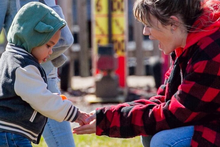 Parent and child collecting eggs at the Blake’s Orchard and Cider Mill Easter egg hunt during a family friendly spring event in Armada