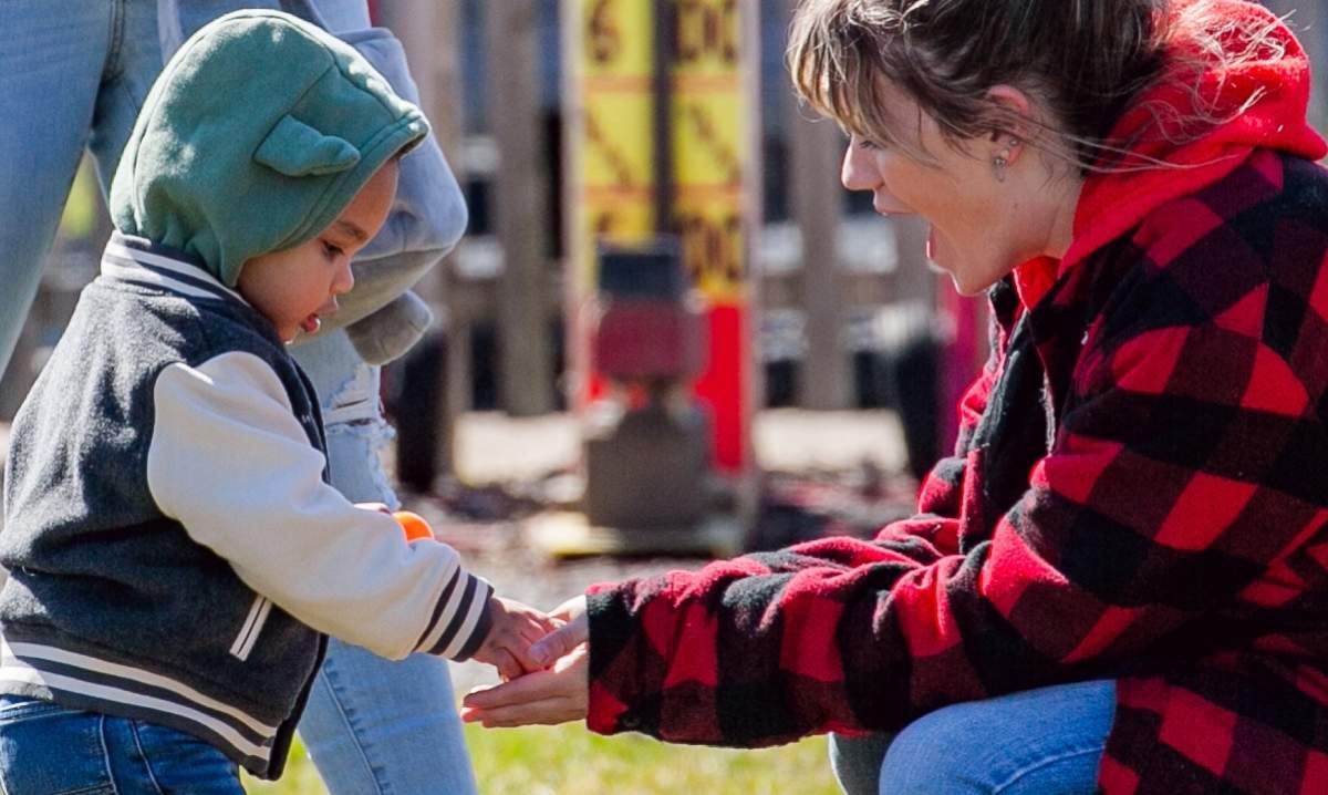 Parent and child collecting eggs at the Blake’s Orchard and Cider Mill Easter egg hunt during a family friendly spring event in Armada
