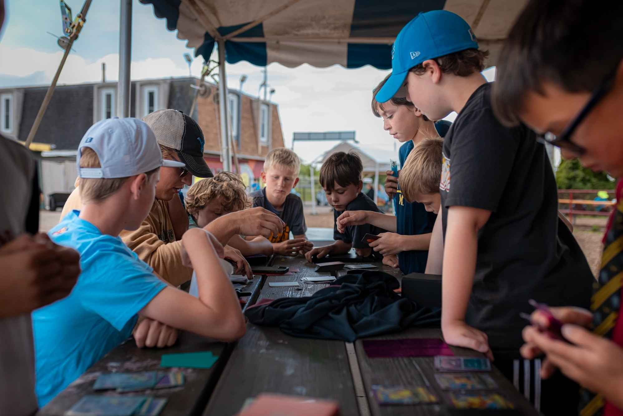 Kids play a card game together at Camp Mirage summer camp in metro Detroit, enjoying a social themed day camp activity outdoors
