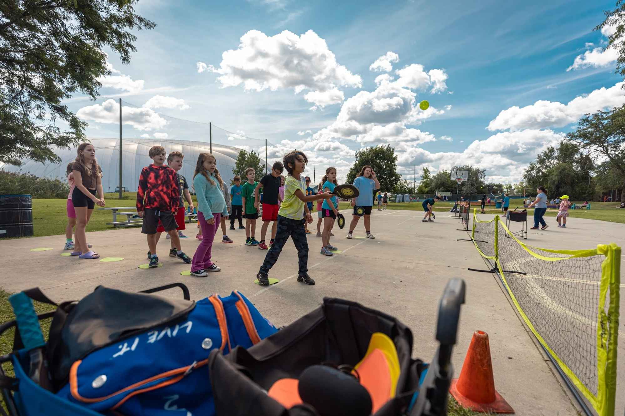 Kids play pickleball at Camp Mirage summer camp in metro Detroit, enjoying outdoor activities and active themed day camp fun