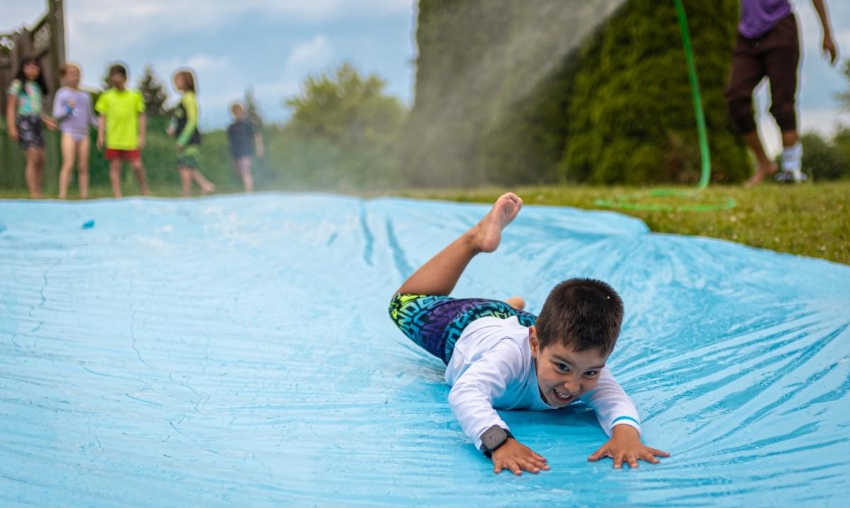 kid sliding on slip n slide at camp mirage