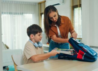 What helps my child get dressed and out the door without daily battles? Parent helping child with autism pack backpack and get ready for school as part of morning routine