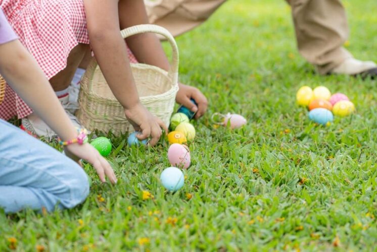 Kids collect colorful eggs during the Easter egg hunt Macomb Place Mount Clemens event while filling baskets on the grass outdoors