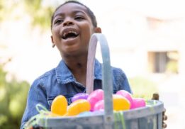 The Great Easter Egg Hunt at Lighthouse Elementary School with child holding colorful eggs in basket during fun outdoor hunt