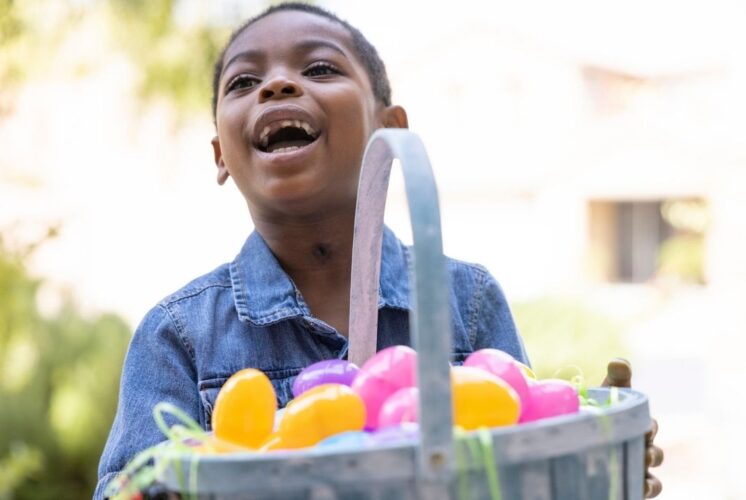 The Great Easter Egg Hunt at Lighthouse Elementary School with child holding colorful eggs in basket during fun outdoor hunt