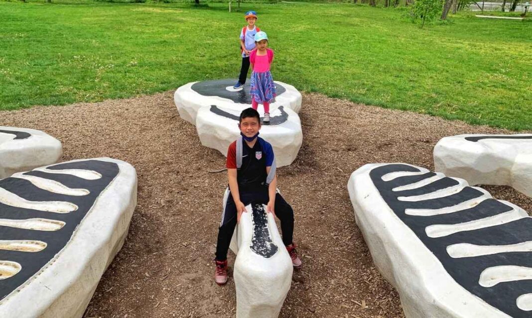 Kids play on a playground in Indianapolis during spring break, enjoying outdoor family fun and fresh air on a road trip from metro Detroit