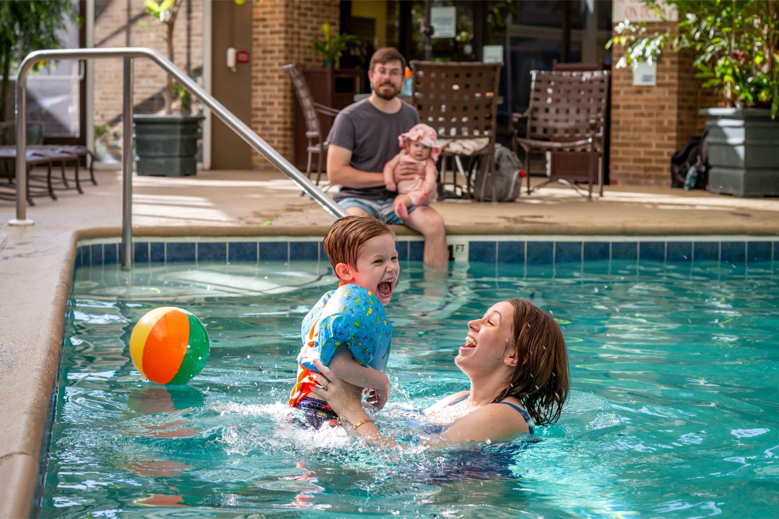 A family enjoys a hotel pool in Lansing during spring break, giving kids a fun indoor activity while parents relax nearby